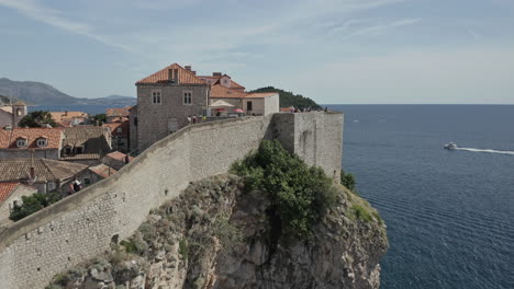 the old town of dubrovnik, croatia along the adriatic sea with fortified walls along cliff edge.