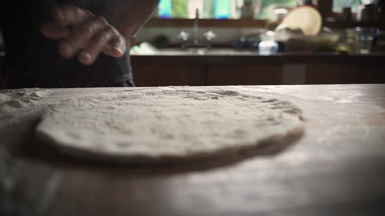 chef masculino amasando masa de pizza casera en la mesa de madera 1 cámara lenta 60fps