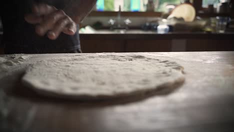 Male-chef-kneading-homemade-pizza-dough-on-wooden-table-1-Slow-Motion-60FPS