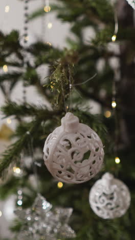 video pov: persona termina de decorar el árbol de navidad, las manos permanecen admiradas sobre un adorno recién colgado