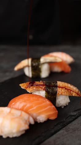 preparing sushi platter with salmon, shrimp, eel