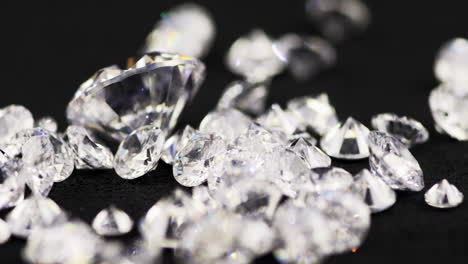 toma macro en cámara lenta de diamantes de varios tamaños de corte brillante reales que se arrojan sobre la mesa de clasificación en una joyería para un examen más detenido