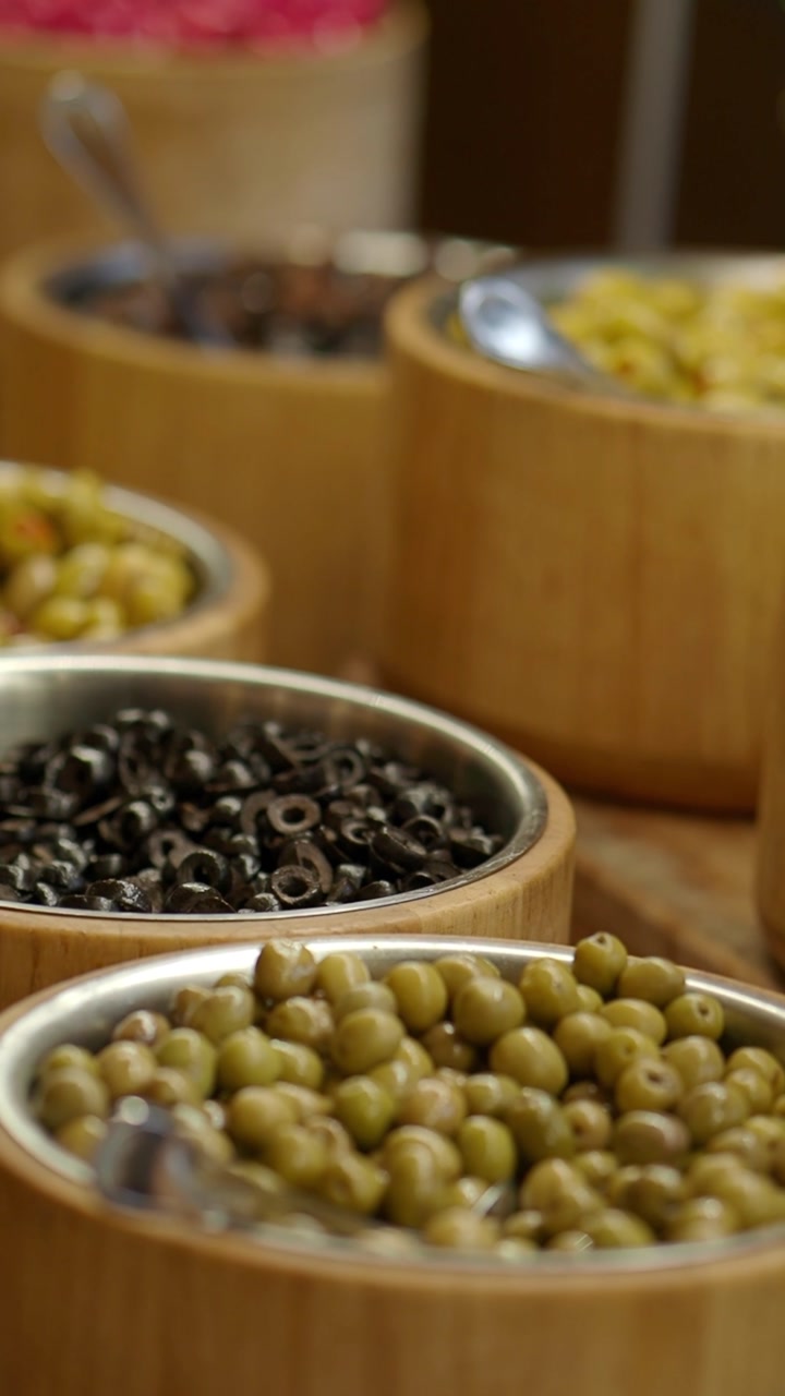 Close-up of Green and Black Olives with Pickled Vegetables on Buffet
