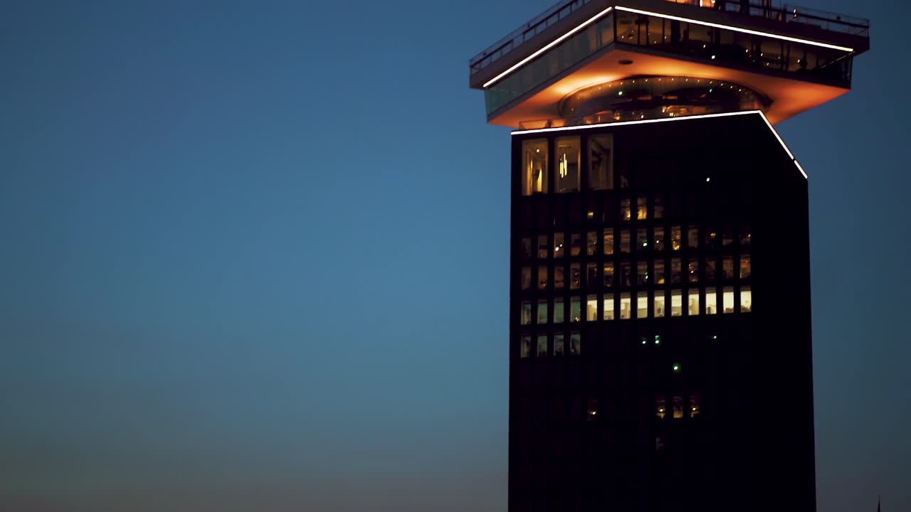 View moving from Eye film museum towards the rooftop terrace of Adam lookout tower in Amsterdam during twilight