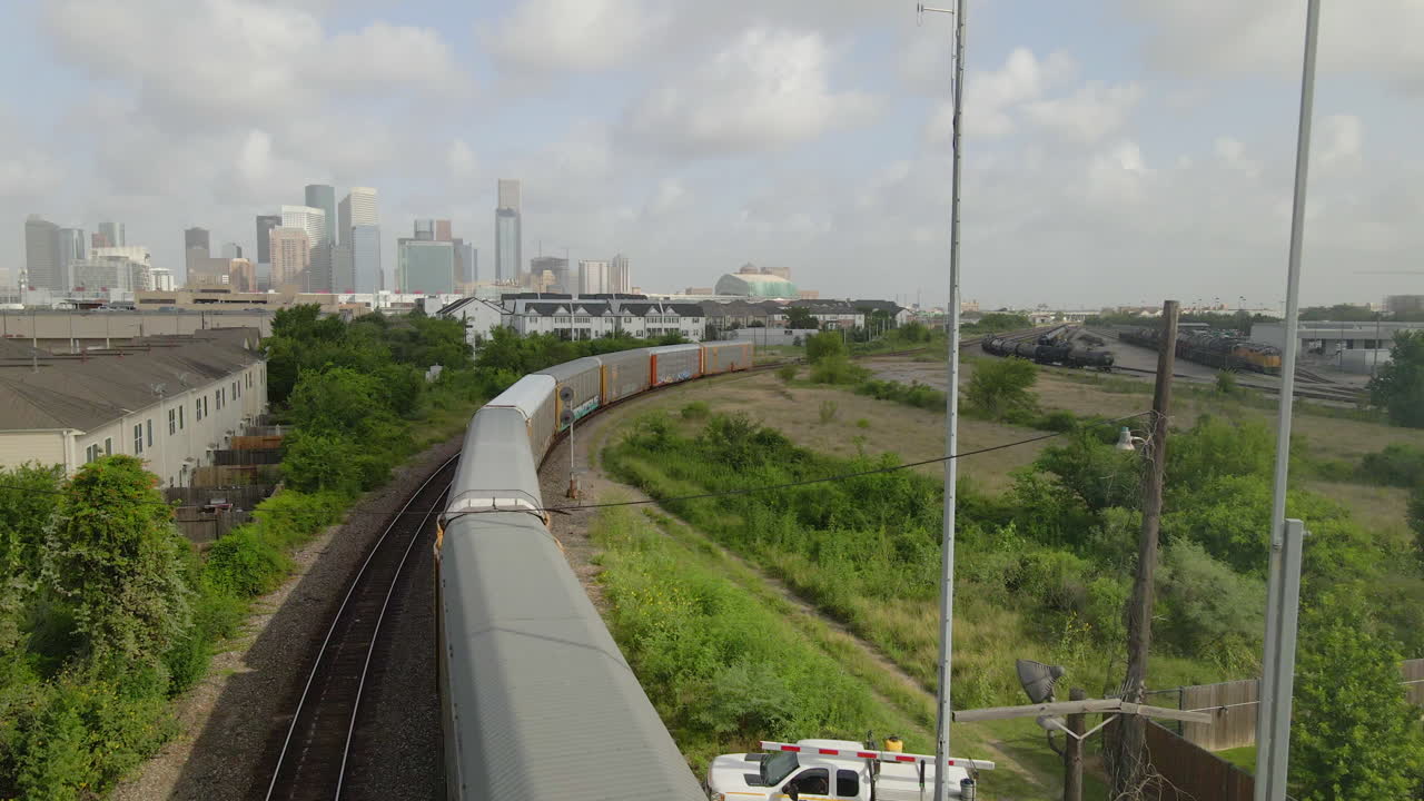 Aerial view of moving train with the Houston skyline in the background.
