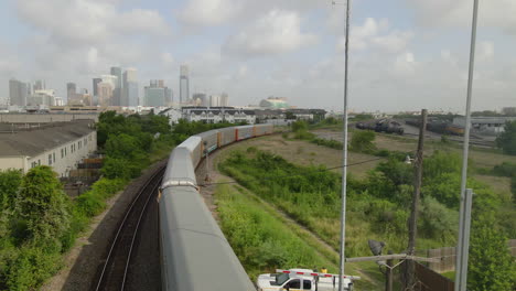 aerial view of moving train with the houston skyline in the background.