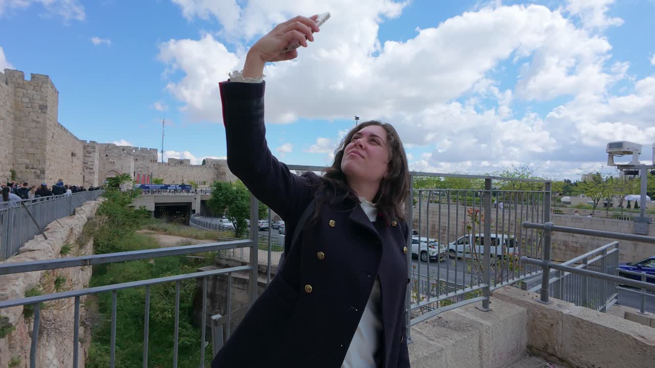 Young Woman Texting on Smartphone Near Old City Walls of Jerusalem. Slow motion.
