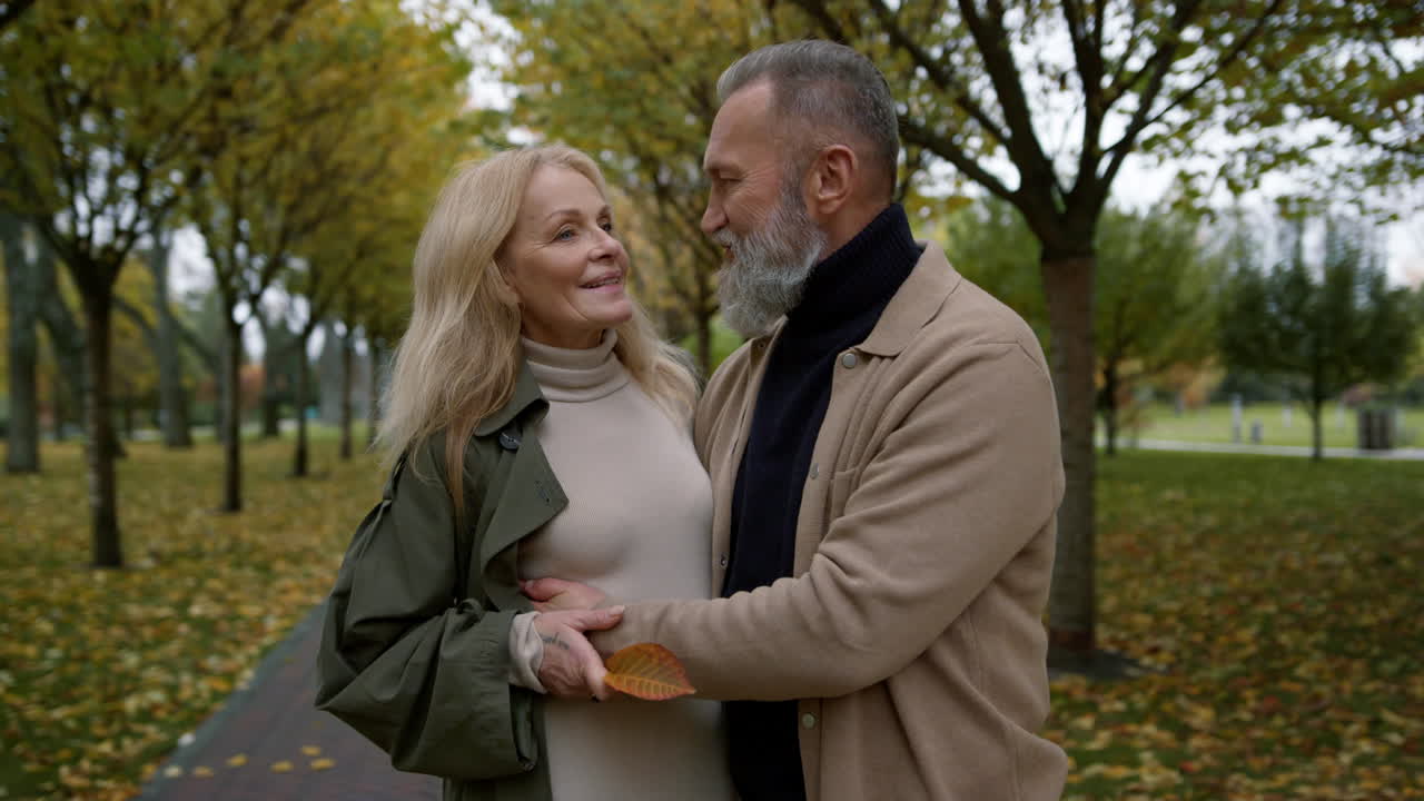 Happy couple hugging in autumn park. Close up romantic lovers talking.