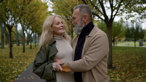 una pareja feliz abrazada en el parque de otoño. amantes románticos hablando de cerca.