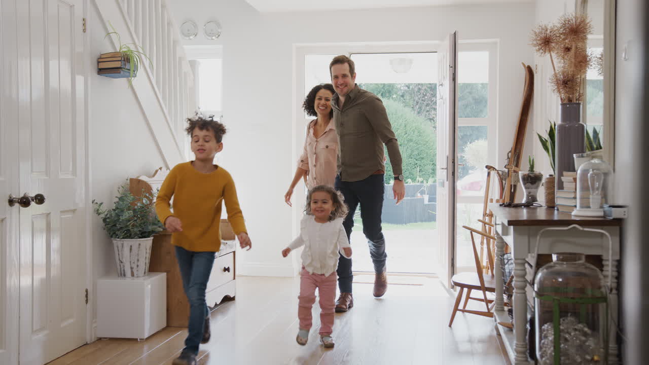 Familie keert na een uitje naar huis terug met enthousiaste kinderen die vooruitrennen.