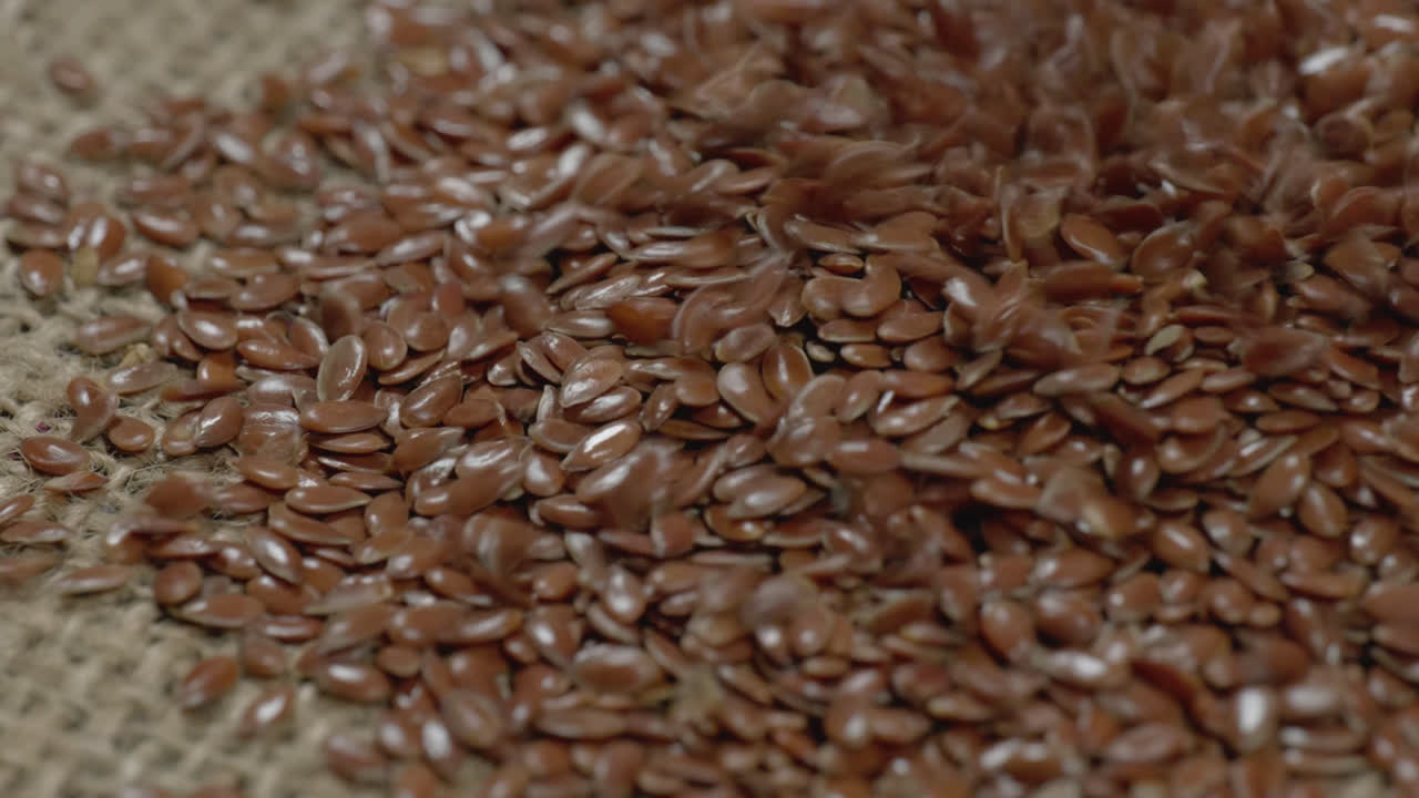 flax seeds falling on white surface and bouncing , 4k , stable shot