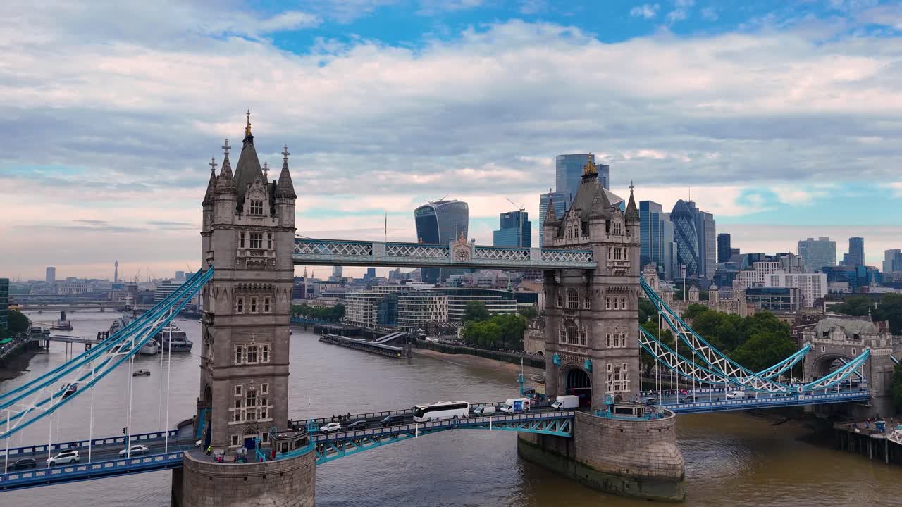 A breathtaking drone ascent from the River Thames, revealing the iconic Tower Bridge. The camera glides upward, showcasing the stunning contrast between historic London and the modern City skyline.