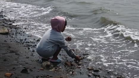 a girl playing on the shore of baruna beach, semarang, central java, indonesia