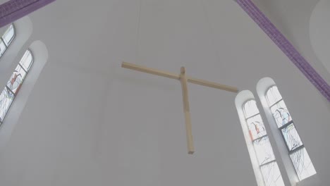 a wooden cross hangs in a sanctuary for holy week just before easter, wide angle