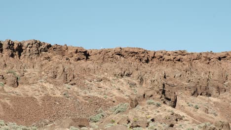 blue sky hiker walks along rim of frenchman coulee in wa scablands