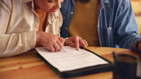 una pareja joven revisando papeles juntos en casa