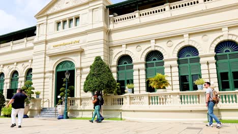 visitors walking by historic architecture in bangkok