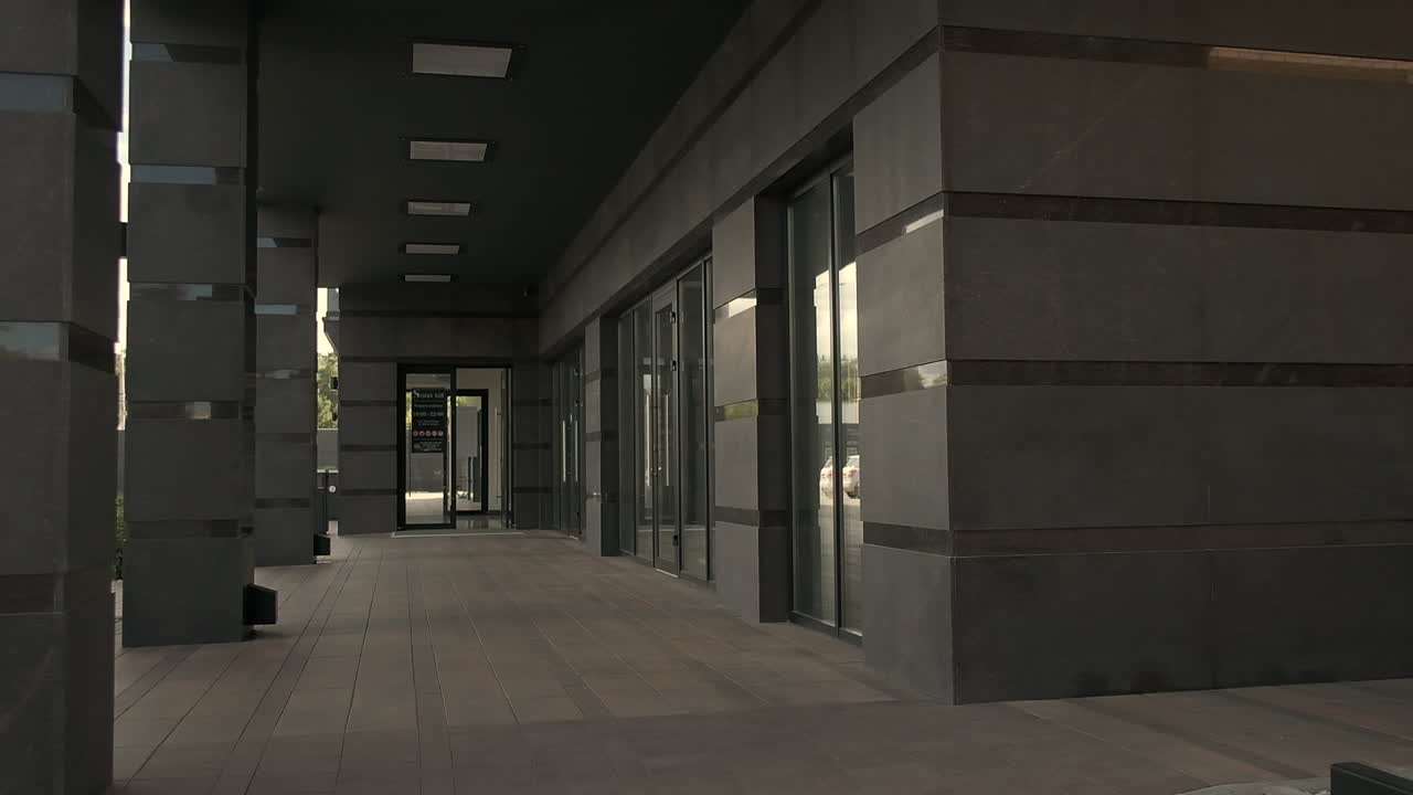 hombre de negocios montando un scooter eléctrico frente al edificio de oficinas