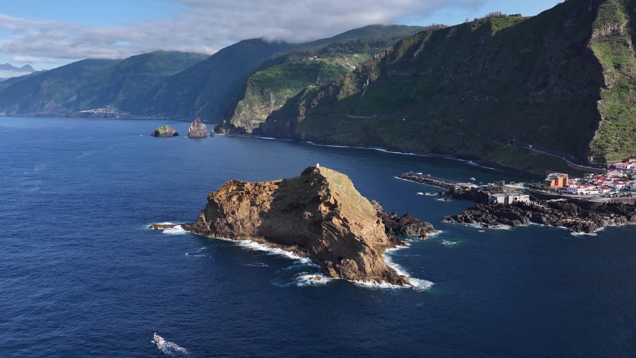 Rugged islet Ilhéu Mole off Porto Moniz coastline, Madeira. Aerial pullback view