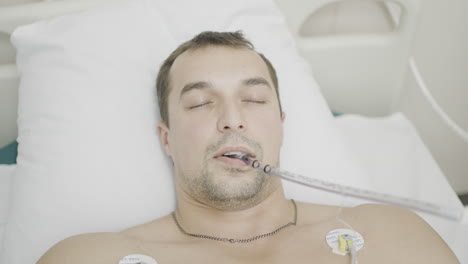patient in hospital bed with breathing tube