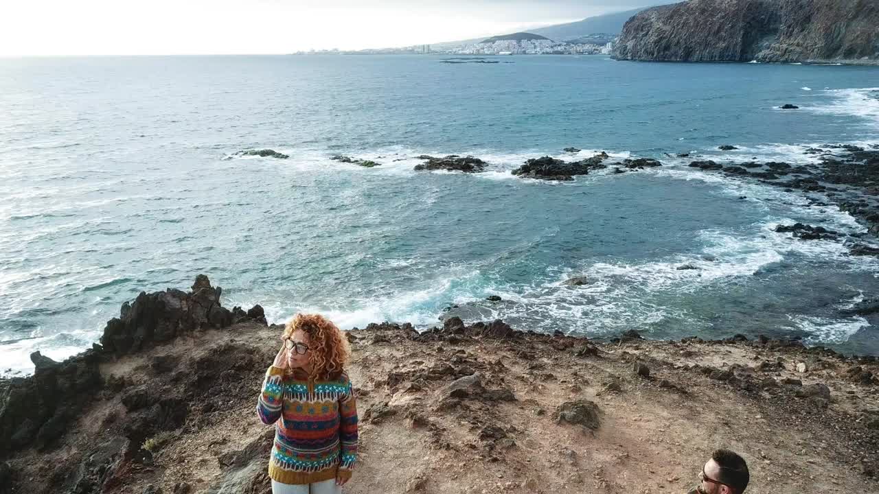 oficina abierta alternativa en el acantilado frente al océano con hombre y mujer trabajando