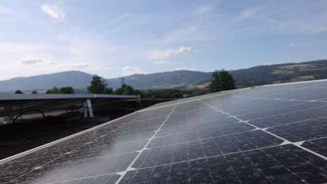 Drone-trucking-Shot-of-solar-panels-units-of-roof-with-swiss-alps-in-background---Production-of-green-energy-with-sunlight