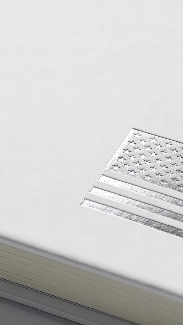 Vertical video: Start cam panning revealing foil flag on white box showing layered edge, copy space