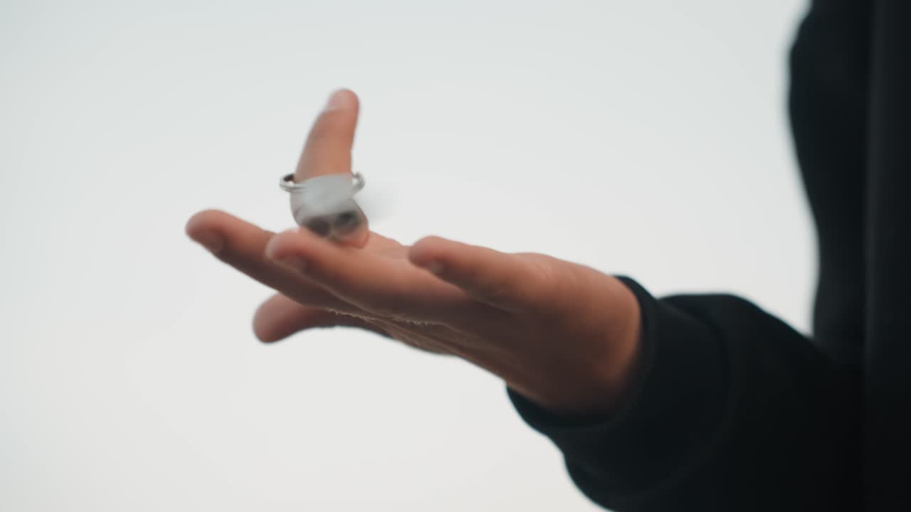 Primo piano di una mano che lancia con sicurezza una chiave con velocità. Mano che fa ruotare ed lancia energicamente un portachiavi con sicurezza. Il primo piano cattura una mano caucasica che lancia e fa roteare con sicurezza e rapidamente un portachiavi.