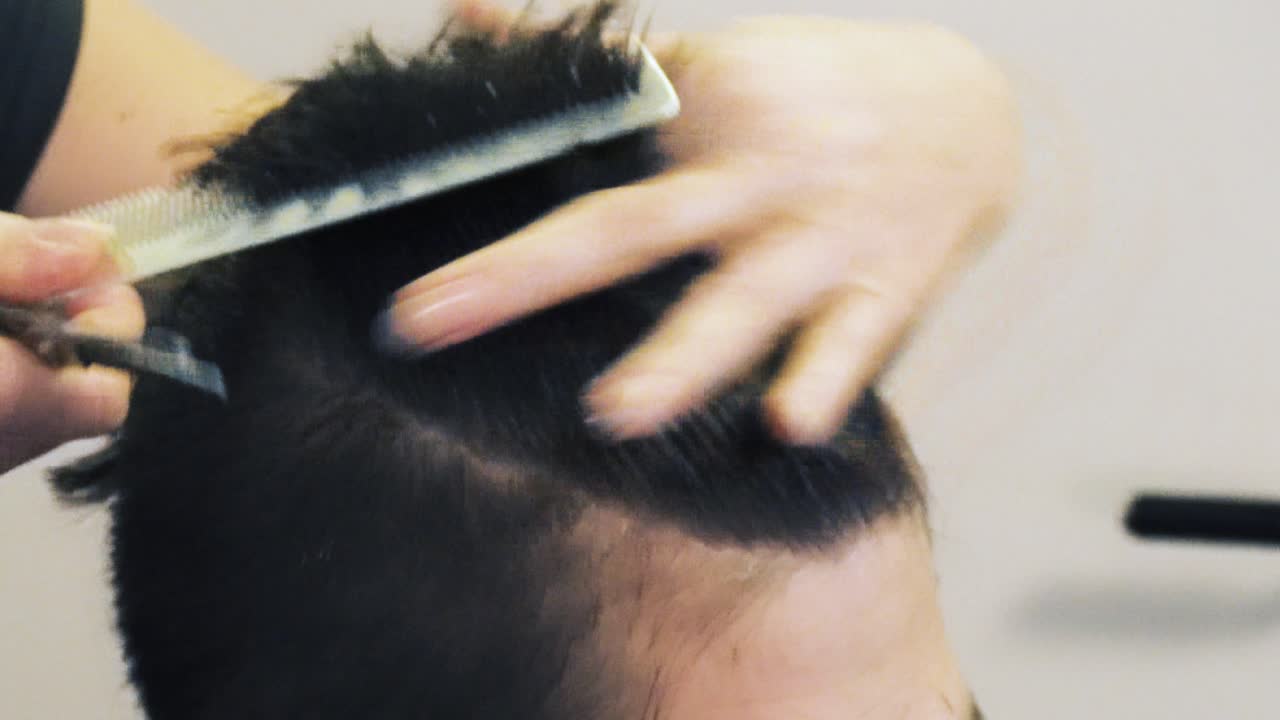 peluquero aficionado cortando el pelo largo primer plano