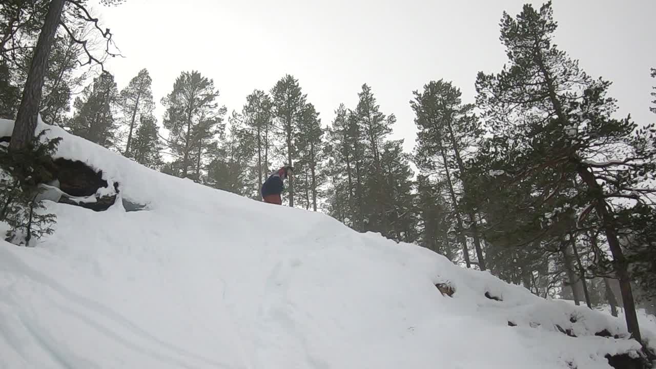 Uno snowboarder si lancia nel fuoripista. Cade e fa un tomahawk, ricoprendosi di neve - Al rallentatore.