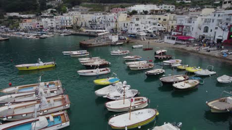 dolly aéreo sobre barcos de pesca y de velocidad anclados en filas en la isla de capri, italia