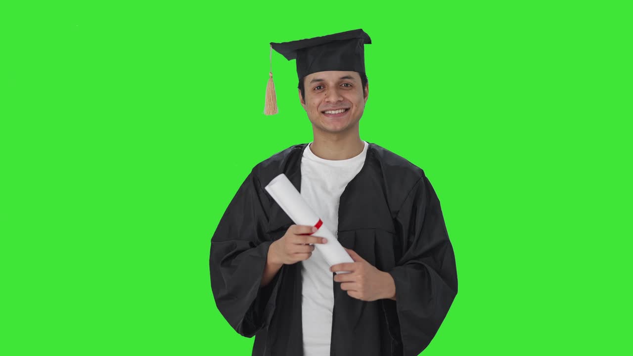 Felice studente universitario indiano in piedi con la laurea Green screen
