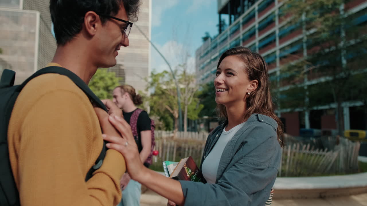 Two friends, European male and female students in casual clothes talking with