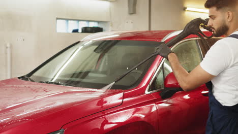 man washing a red suv