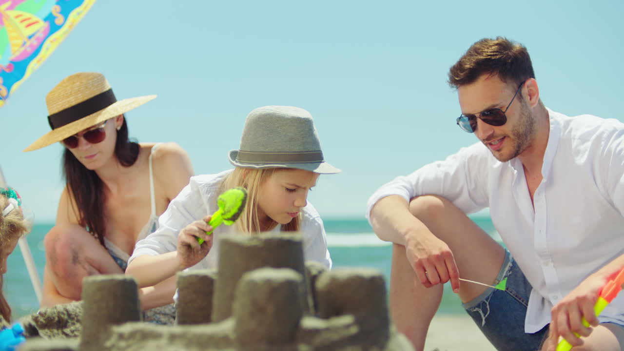 Familia construyendo castillos de arena en la playa
