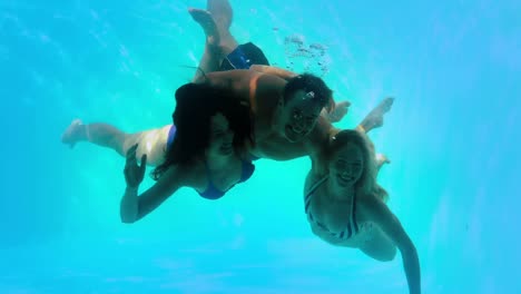 amigos nadando bajo el agua en la piscina juntos