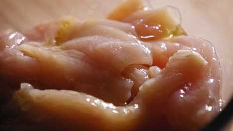 seasoning fresh chicken breast strips in a bowl