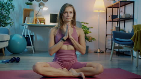 mujer practicando yoga en una sala de estar