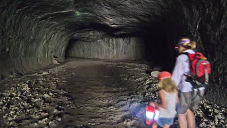 a mother and daughter hiking into subway caves made from a lava tube in lassen national forest california