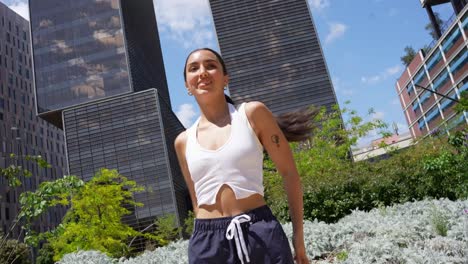 woman dancing in an urban park with modern architecture