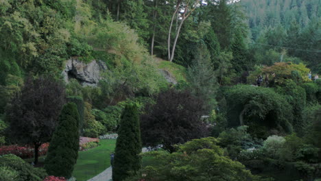 la cámara recorre los intrincados jardines butchart en columbia británica, canadá, revelando impresionantes macizos de flores, paisajes, vida vegetal y personas caminando