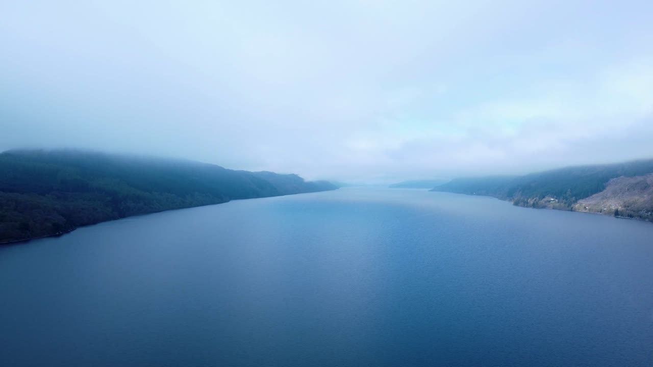 Pohled z výšky přes zamlžené jezero Lough Ness, pomalu se posouvající doprava. Pořízeno brzy ráno před rozptýlením mlhy.