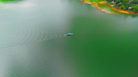 una impresionante perspectiva aérea sigue a un barco mientras se desliza a través de las aguas prístinas de un aislado lago de montaña