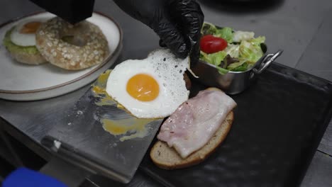 serving breakfast in restaurant kitchen, chef with black gloves