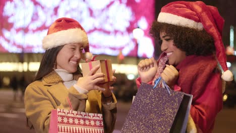 women exchanging christmas gifts