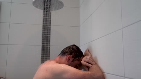 tiro deslizante de un hombre desnudo relajándose mientras toma una ducha