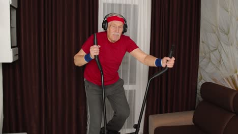 Healthy-elderly-senior-grandfather-model-exercising-sport-workout-on-orbitrek-in-room-at-home