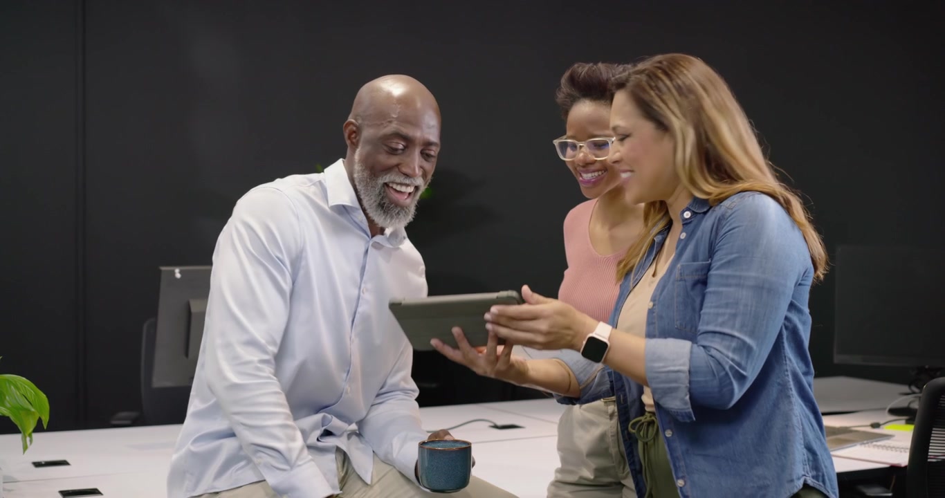 Diverse Business Team Collaborating on Tablet in Modern Office