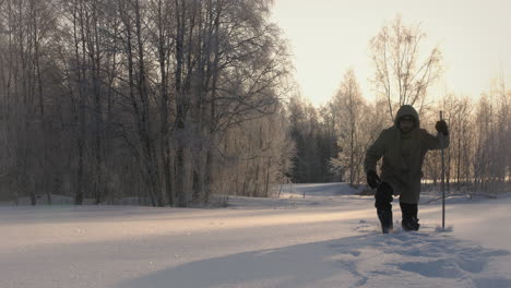 Man-walking-with-difficulties-on-path-covered-by-lot-of-snow