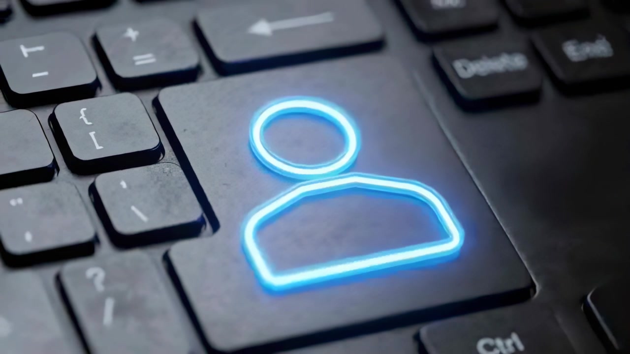 Zooming camera drawing focus to glowing blue user profile key on keyboard at desk, showing smudges